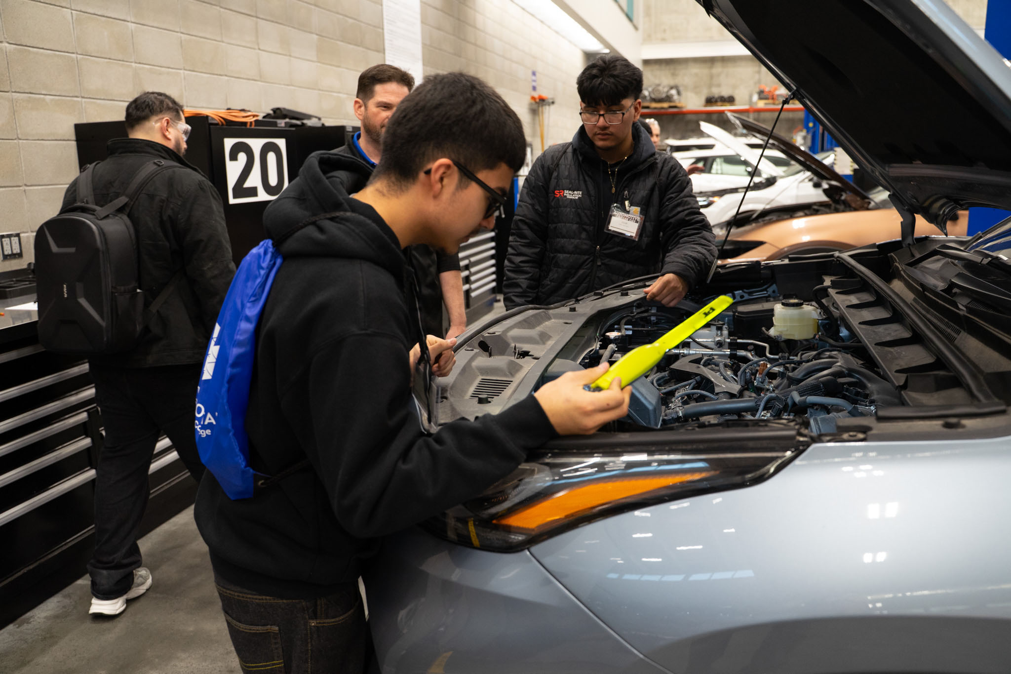 Students inspecting an engine of a vehicle