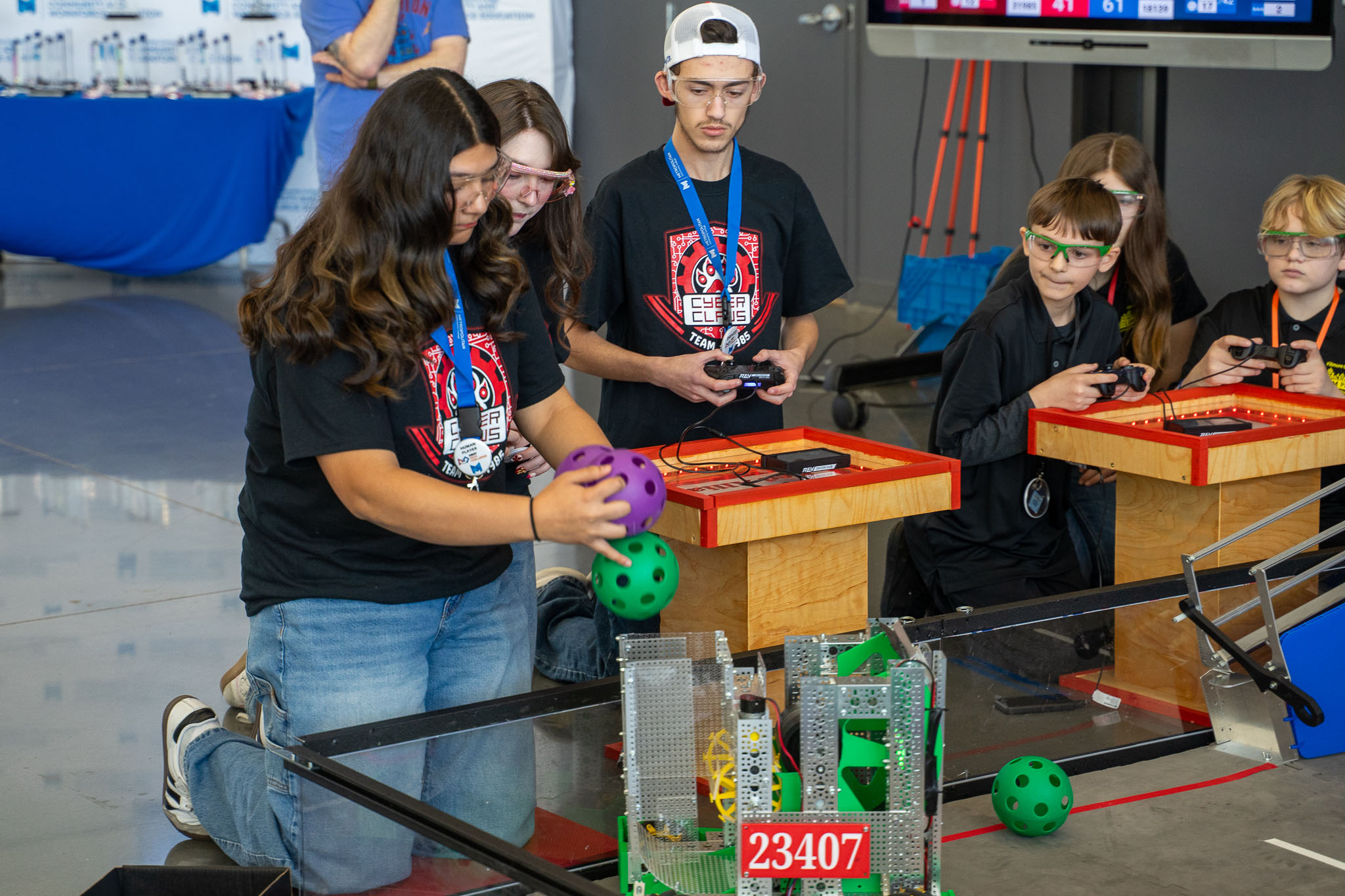 A student loads plastic balls into a robot at the 2026 FTC Nebraska Championship