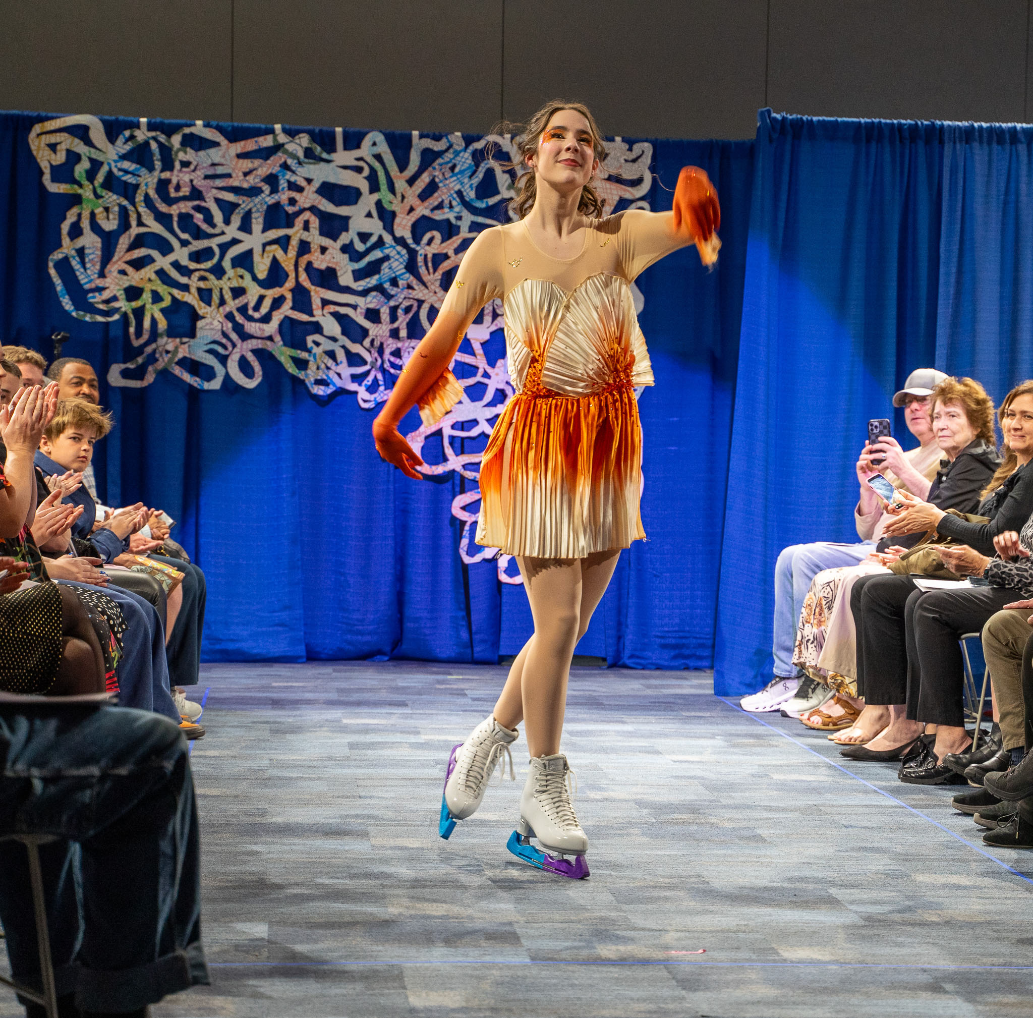 Student model in figure skater dress posing on runway