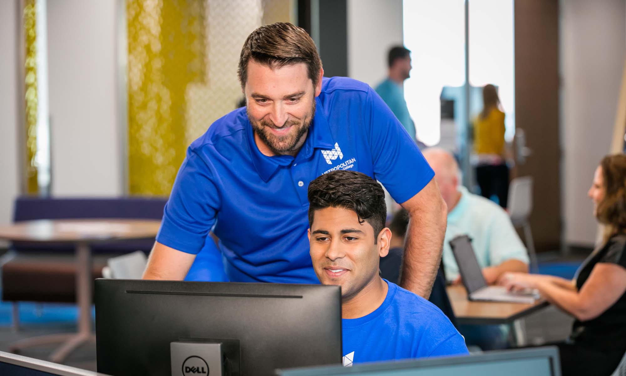 Student working on computer with help of an advisor