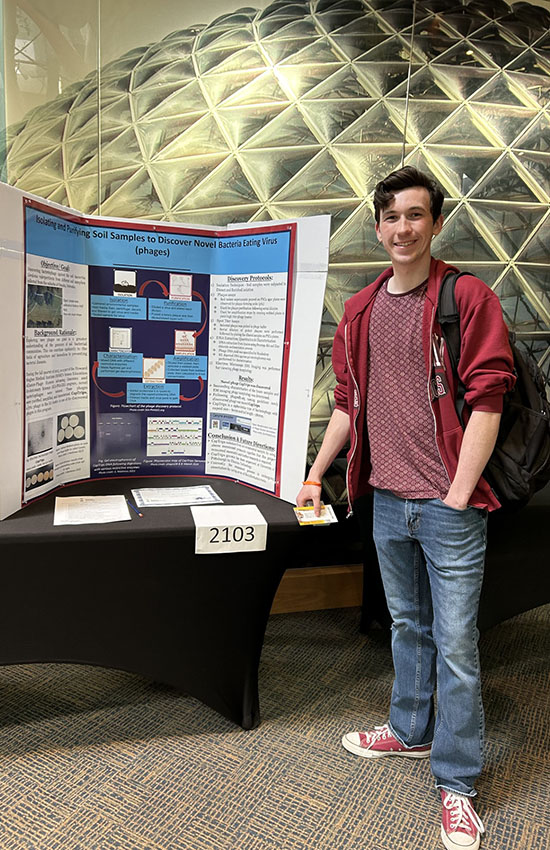Student standing next to infographic