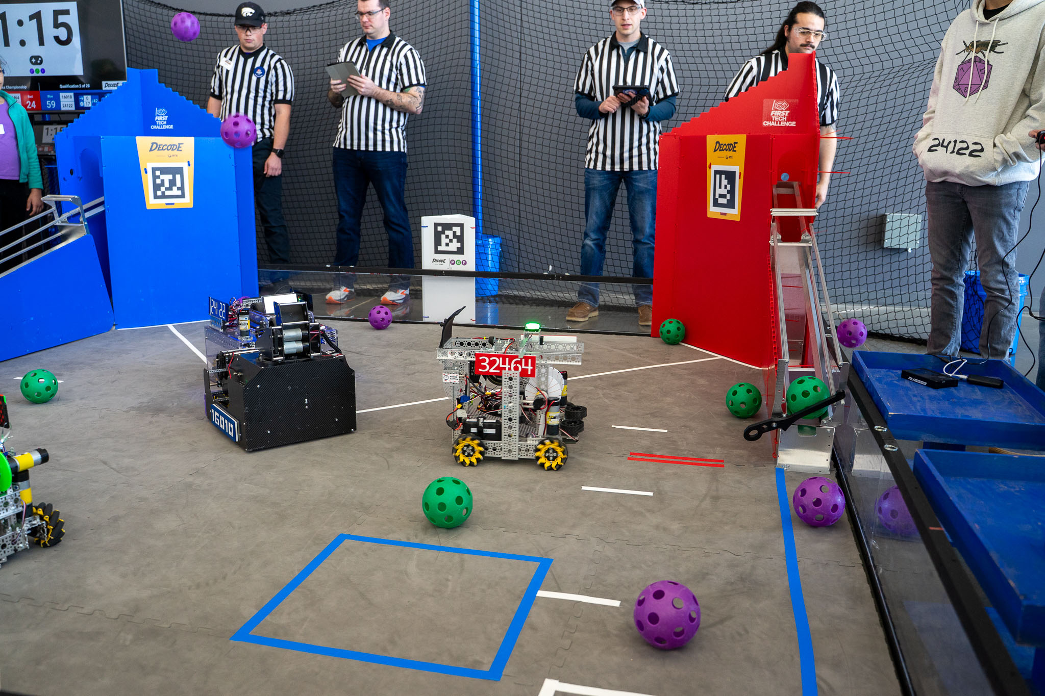 Judges looking on as robots shoot plastic balls into goals at the 2026 FTC Nebraska Championship