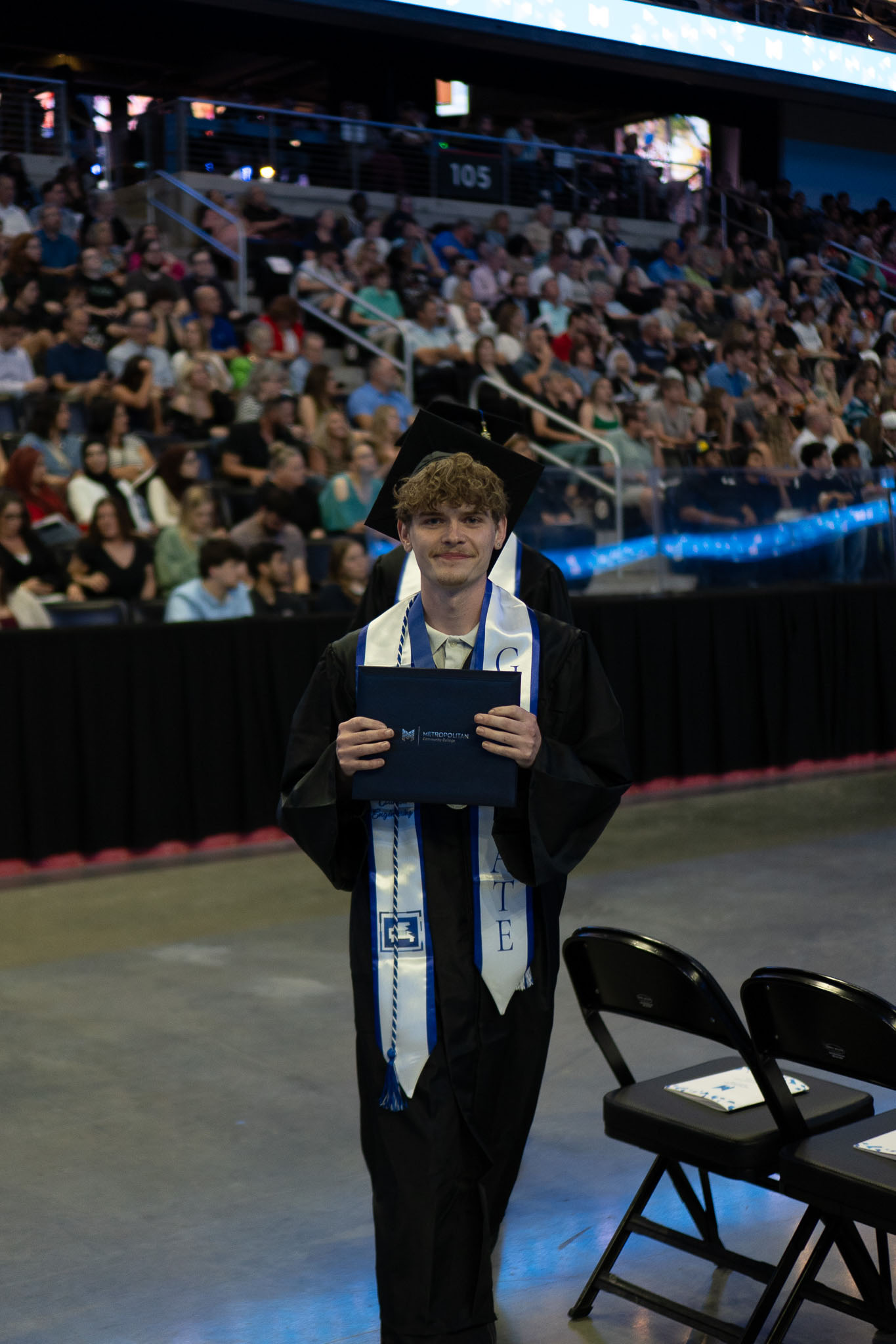 Male student posing with degree