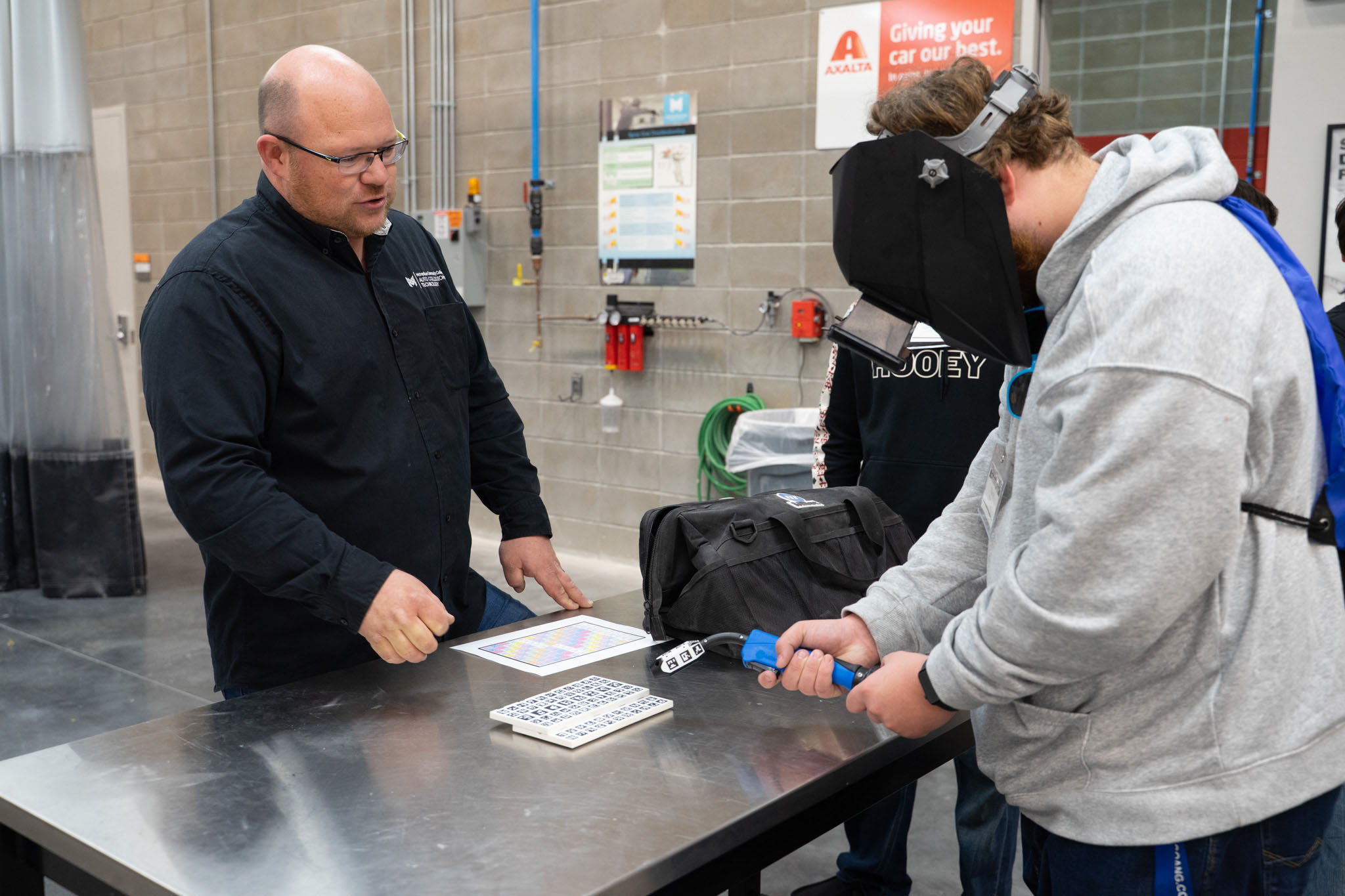 A student and instructor participating in a welding simulation.